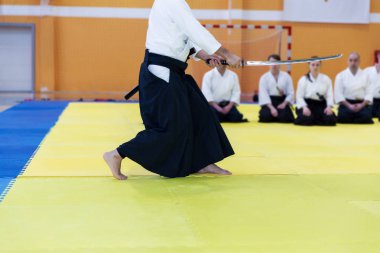 Kimonolu insanlar dövüş sanatları silah eğitimi semineri veriyor.