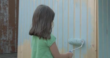 Genç kız bir rulo ile küçük ahşap ev boyama