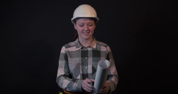 Una joven ingeniera está estudiando un plan de construcción — Vídeos de Stock