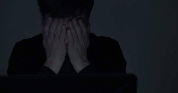 Porträt eines Mannes, der spät in der Nacht im dunklen Raum am Laptop arbeitet — Stockvideo