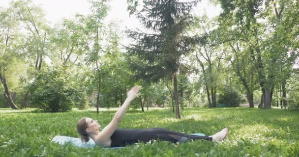 Hermosa mujer haciendo Pilates en el parque verde — Vídeos de Stock