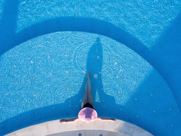 Jonge vrouw zonnebaden in een zwembad — Stockfoto