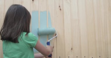 Genç kız bir rulo ile küçük ahşap ev boyama