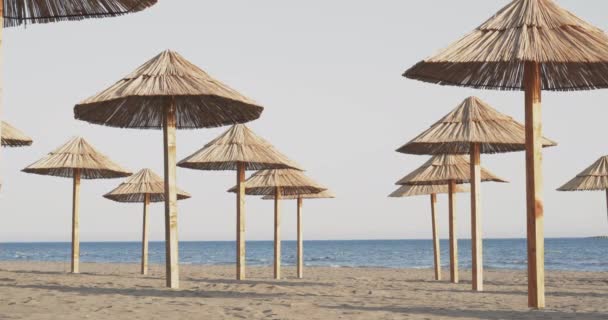 Пляжні парасольки на пляжі на заході сонця — стокове відео
