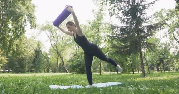 Mooie vrouw doet Pilates in het groene park — Stockvideo