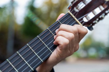 Sonbahar parkında gitar çalan iki arkadaş