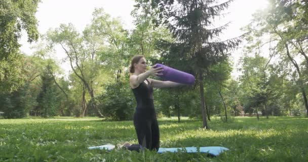 Όμορφη γυναίκα κάνει Πιλάτες στο πράσινο πάρκο — Αρχείο Βίντεο