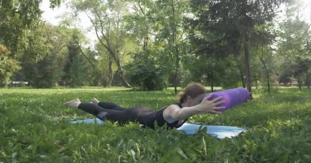 Hermosa mujer haciendo Pilates en el parque verde — Vídeos de Stock