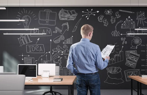 Ung affärsman på modernt kontor med kreativ affärsstrategi skiss ritad på en vägg — Stockfoto
