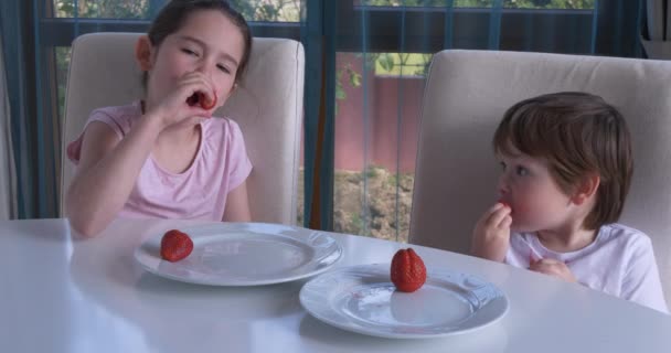 Nette Kinder essen zu Hause frische reife Erdbeeren — Stockvideo