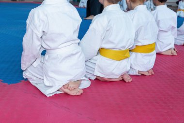 Kimonolu çocuklar tataminin üzerinde oturuyorlar.