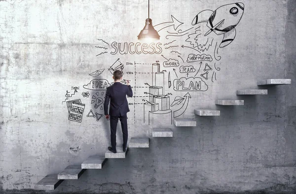 Seorang pengusaha menggambar strategi bisnis kreatif di dinding beton dengan langkah-langkah di dalamnya — Stok Foto