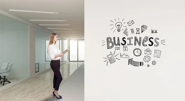 Seorang pengusaha yang berdiri di kantor modern dengan sketsa strategi kreatif yang digambar di dinding putih — Stok Foto