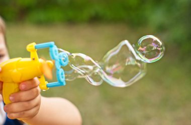 Küçük çocuk sabun köpüğü üfleme olduğunu. Yakın çekim