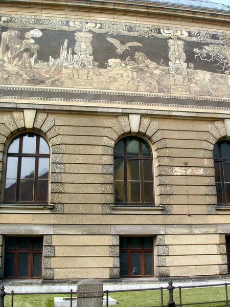 Architectural beauty unfolds in Poznan, where intricate murals grace the National Museums facade, inviting admiration from passersby under the clear sky.