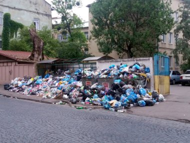 Lviv, Ukrayna - 17 Haziran 2017 Çöp yığını çöp yığını sokağa dökülüyor ve kaotik bir manzara yaratıyor. İhmal edilen bölge binalarla çevrili.