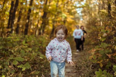 mutlu küçük çocuk, gülen ve sonbahar Parkta oynayan bebek kız