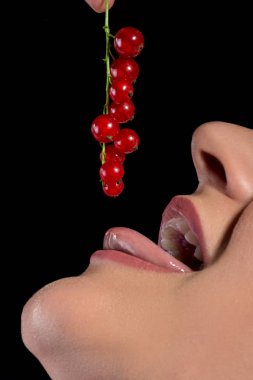 siyah zemin üzerine kırmızı kuş üzümü yiyen kız ağız