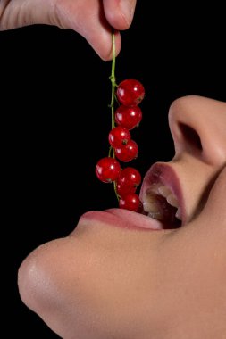 siyah zemin üzerine kırmızı kuş üzümü yiyen kız ağız