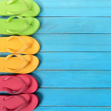 Mavi arka plan ağaç plaj zemin kaplaması üzerinde parmak arası terlik yan kenarlık satırı