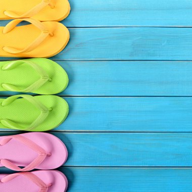 Mavi arka plan ağaç plaj zemin kaplaması üzerinde parmak arası terlik yan kenarlık satırı