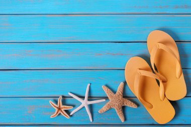 Flip flop denizyıldızı eski sıkıntılı parlak mavi plaj ahşap arka plan