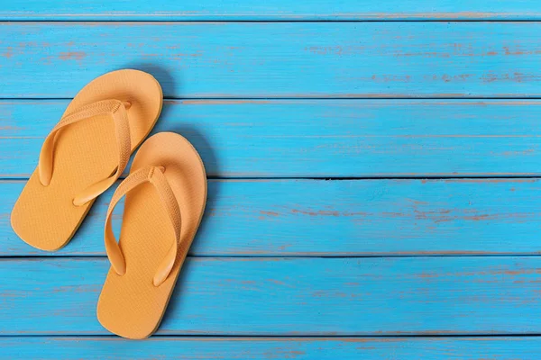 Eski yıpranmış mavi plaj ahşap üzerine floplar flip