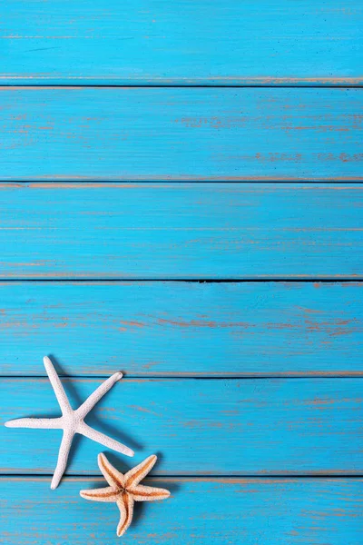 Deniz yıldızı eski mavi plaj ahşap güverte arka plan dikey yıpranmış