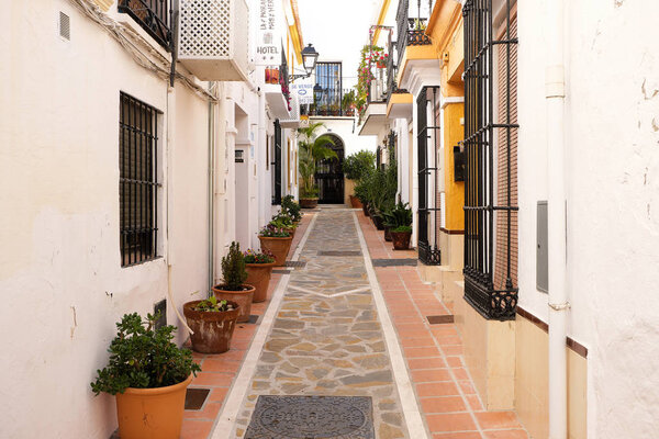 Marbella old town, Andalucia, Spain - March 13, 2019 : traditional whitewashed village houses and narrow street