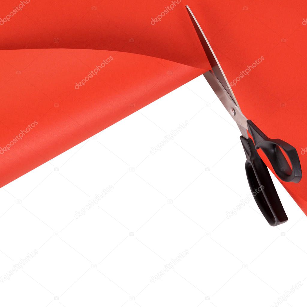 Scissors cutting red paper background