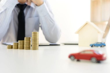 Genç iş adamı ofiste masa yığını sikkelerinde çalışması 