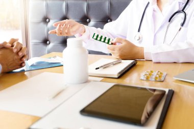 Doktor kendine iyi bak, hasta hasta belirtiler açıklayan veya evrak işi birlikte bir consultatio tartışmak gibi bir soruyu soran bir erkek doktor dikkatle dinlerken