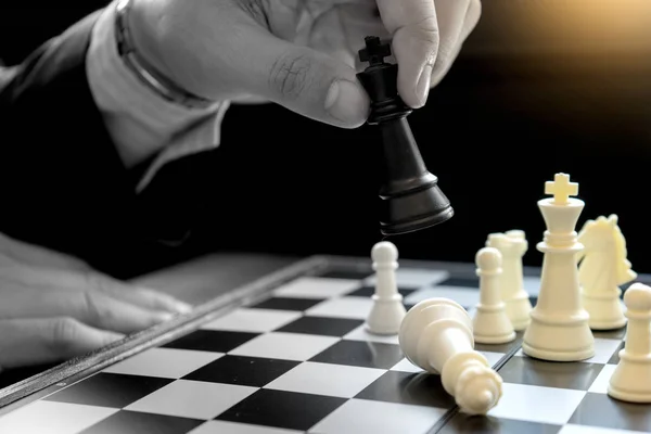 Businessman play chess use King Chess Piece white to crash overthrow the competitor concept business strategy for win