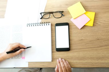 Kadın ve erkek eğitim veya iş için dizüstü bilgisayar ve kağıt işi renk kalemleriyle masada çalışırlar.