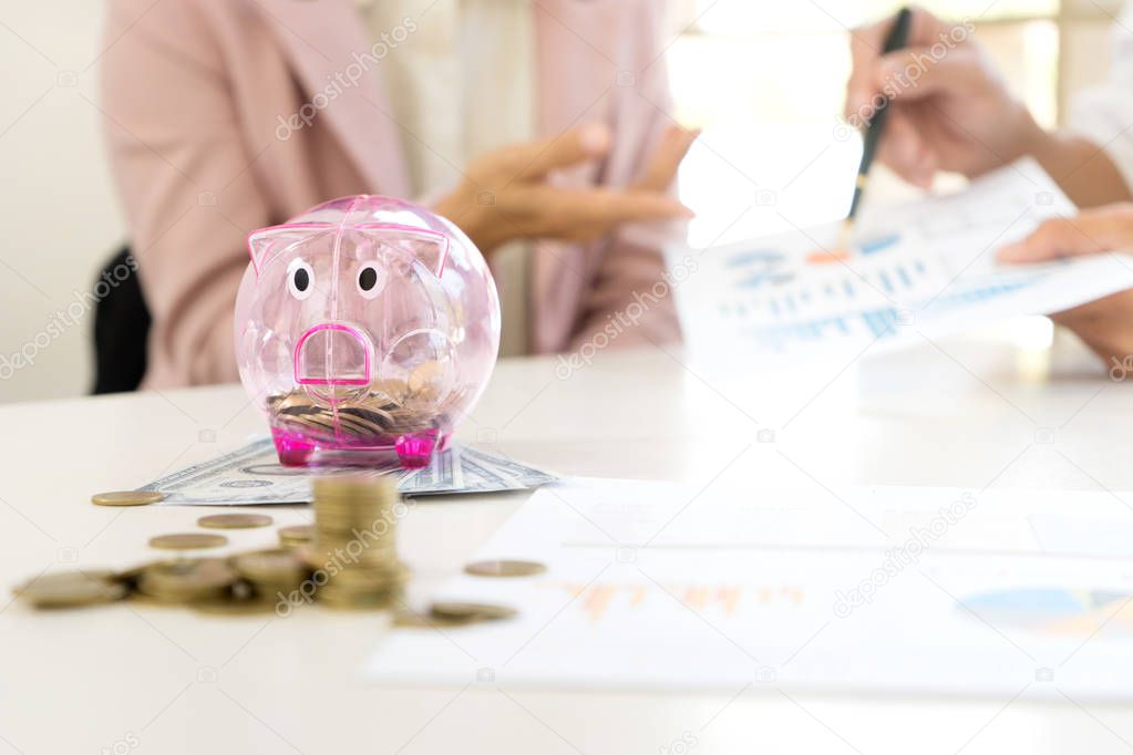 Business man woman hold collect coin in the row in front of the saving box concept economy investment