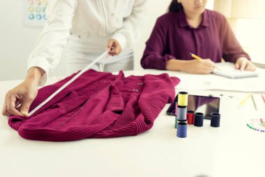  profesyonel moda tasarımcısı çalışma ve çizim ile bilgisayar tablet ve renkli grafikleri tabloda skeçler.