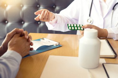 Doktor kendine iyi bak, hasta hasta belirtiler açıklayan veya evrak işi birlikte bir consultatio tartışmak gibi bir soruyu soran bir erkek doktor dikkatle dinlerken