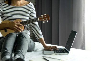 Genç kadın ile onun Ukulele oyun yazmak bir şarkı ya da müzik