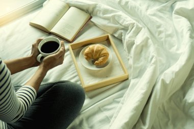 kadın okuma yatağın üzerine bir kitap ona kahvaltı ile mutlu bir hayat gün için sakin ol