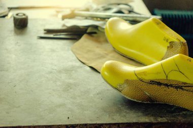 Ayakkabı maker iş yerinde aracı ve hammadde sarı ayak manken ve deri ile