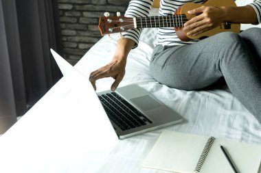 Genç kadın ile onun Ukulele oyun yazmak bir şarkı ya da müzik