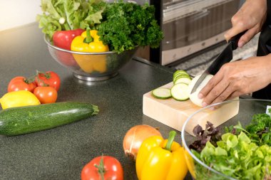 Genç Asyalı kadın iş için salata yiyecek ile modern mutfakta yemek sağlıklı