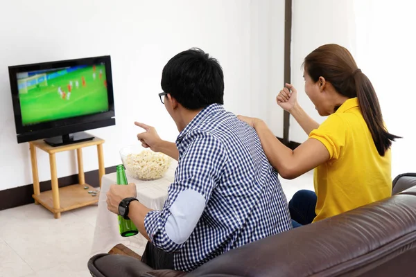 man and woman watch Football match on tv broadcast program cheer and existing together in family