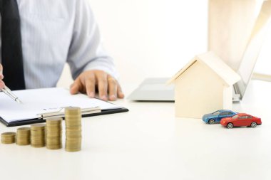 Genç iş adamı ofiste masa yığını sikkelerinde çalışması 