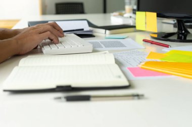 Kadın ve erkek eğitim veya iş için dizüstü bilgisayar ve kağıt işi renk kalemleriyle masada çalışırlar.