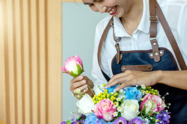 Yapay çiçek süslemeleri için çalışan sanatçı kadın çiçek süslemeleri ile kağıt ve plastik çiçek birçok renk tabloda