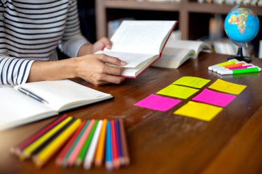 kadın ve adam dizüstü dizüstü bilgisayar ve Kütüphane odadaki kağıt iş renk kalem masada eğitim ya da iş için çalışmak