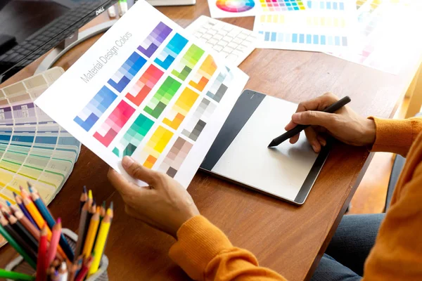 年轻女子用电脑平板电脑电子笔和彩色图表在木桌上从事平面设计工作 — 图库照片