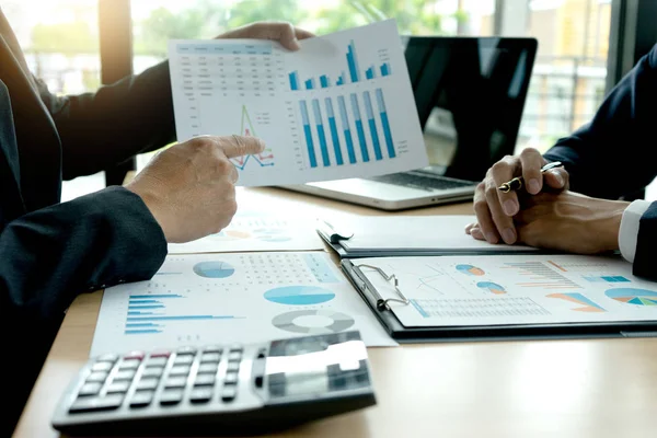 Ofisteki küçük bir toplantıda genç iş adamları bilgisayar laptopuyla grafiksel pazarlama planı hakkında konuşuyorlar..