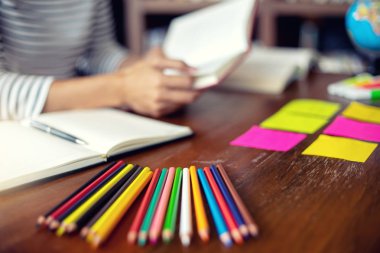 kadın ve adam dizüstü dizüstü bilgisayar ve Kütüphane odadaki kağıt iş renk kalem masada eğitim ya da iş için çalışmak